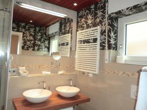 Zwei Waschbecken in einem Badezimmer mit schwarz-weißer Tapete in der Unterkunft Hotel Altenberg in Baden-Baden + 34 Fotos