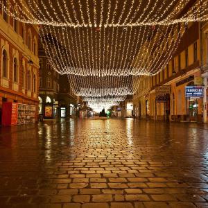 an empty street with christmas lights hanging from the ceiling at Duplex Alexander in Braşov