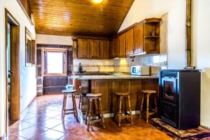 uma cozinha com armários de madeira e bancos de bar em "Casa Da Russa" Mountain Experience em Vila Real