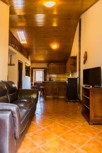 a living room with a leather couch and a kitchen at "Casa Da Russa" Mountain Experience in Vila Real