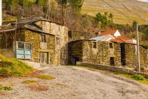 ein altes Steingebäude am Rande eines Feldwegs in der Unterkunft "Casa Da Russa" Mountain Experience in Vila Real