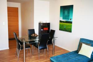 a dining room with a glass table and black chairs at Vega Apartment for Rent in Quito