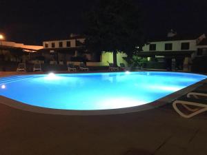 a large blue swimming pool at night at Casa da Bia in Quarteira