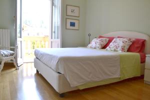 una camera da letto con un grande letto bianco con cuscini rosa di Il Pettirosso a Monsummano