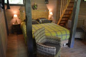 a bedroom with a bed and two wicker chairs at LES GITES INSOLITES DE LA CASCADE in Lespesses