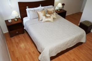 1 dormitorio con 1 cama blanca grande con almohadas en Vega Apartment for Rent, en Quito
