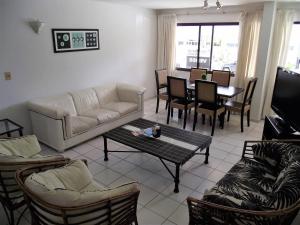sala de estar con sofá, sillas y mesa en Apartamento con todo incluido casi Gorlero, en Punta del Este