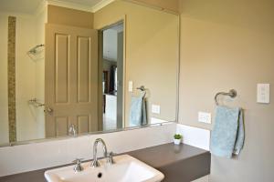 La salle de bains est pourvue d'un lavabo et d'un grand miroir. dans l'établissement Melawondi Spring Retreat, à Imbil