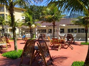 a group of chairs and tables in front of a building at Loft Condado Aldeia dos Reis 216 in Mangaratiba