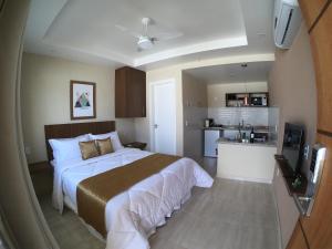 um quarto com uma cama grande e uma cozinha em Areias de Tucuns Lofts e Apartamentos em Búzios