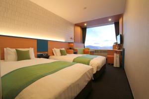 Habitación de hotel con 2 camas y ventana grande. en Minakami Kogen Hotel 200, en Minakami