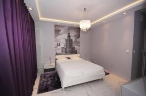 sypialnia z łóżkiem i obrazem na ścianie w obiekcie Apartamenty Triston Park w Warszawie