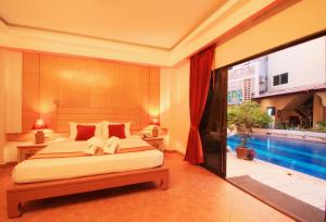 a bedroom with a bed and a swimming pool at Baan Boa Resort in Patong Beach