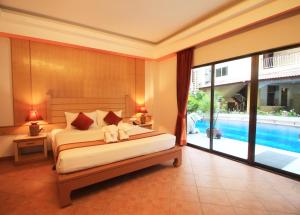 a bedroom with a bed and a swimming pool at Baan Boa Resort in Patong Beach