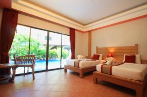a bedroom with two beds and a view of a pool at Baan Boa Resort in Patong Beach