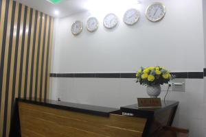een kamer met klokken aan de muur en een tafel bij Phuc Hau Hotel in Con Dao