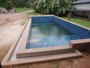 Una piscina de agua con azulejos azules. en Leelawadee Khao-lak en Khao Lak