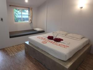 ein Schlafzimmer mit einem Bett mit roten Blumen darauf in der Unterkunft Leelawadee Khao-lak in Khao Lak