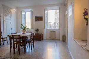 a dining room with a table and chairs and windows at Residenza d'Epoca " Il Campo" by FrancigenaApartments in Siena