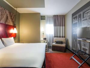 a hotel room with a large bed and a chair at ibis Bordeaux Centre - Gare Saint-Jean in Bordeaux