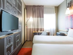 a hotel room with a bed and a flat screen tv at ibis Bordeaux Centre - Gare Saint-Jean in Bordeaux
