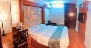 a bedroom with a large bed with a wooden headboard at Star Guest House in Karachi