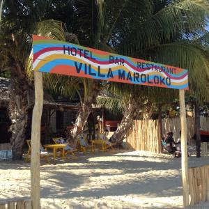 a sign on the beach in front of a resort at Villa Maroloko in Ifaty