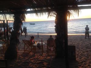 a group of people sitting at a table on the beach at Villa Maroloko in Ifaty