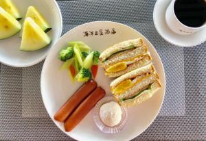 een bord met een broodje en groenten en een kop koffie bij Ocean Star Hotel in Koror