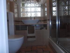 a bathroom with a sink and a toilet and a window at TIA casa vacanza in Bevagna