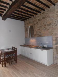 a kitchen with a sink and a table in a room at TIA casa vacanza in Bevagna