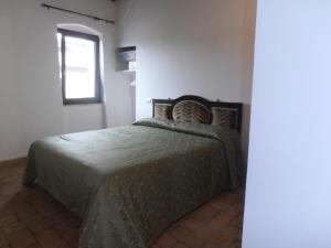 una camera con un letto in una stanza con una finestra di TIA casa vacanza a Bevagna