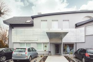 a white building with cars parked in front of it at Hotel Inter in Bielany Wrocławskie