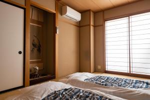 A bed or beds in a room at Guest House Ouka
