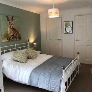a bedroom with a bed with a painting of a rabbit on the wall at The Grey Cottage in Blackford