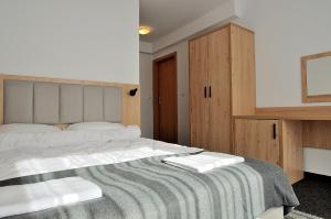 a bedroom with a large bed with two towels on it at Willa Centrum in Zakopane