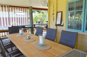 un tavolo in legno in un ristorante con sedie blu di Licuala Lodge a Mission Beach