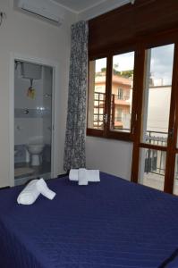 een slaapkamer met een blauw bed met 2 handdoeken erop bij B&B Frangi in Pompei