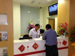 two people standing at a cash register in a store at Caspari Hotel in Tampin