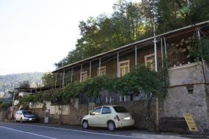 un coche blanco estacionado frente a un edificio en Guest House Nima, en Borjomi