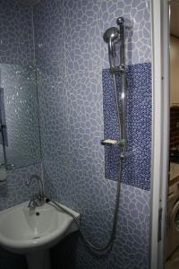 ein blaues Bad mit einer Dusche und einem Waschbecken in der Unterkunft Guest House Nima in Bordschomi