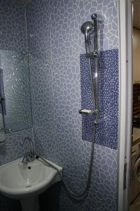a blue bathroom with a shower and a sink at Guest House Nima in Borjomi