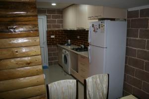 a kitchen with a white refrigerator and a stove at Guest House Nima in Borjomi