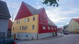 un edificio rojo y amarillo con techo rojo en Gemütliche Gästezimmer in einem neu sanierten Fachwerkhaus, en Sachsenheim