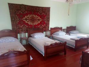 a room with three beds and a red wall at B&B Edem in Haghpat
