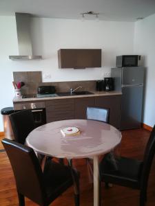 a kitchen with a table and chairs and a table and a kitchen at beau T2 lumineux 1er etage in Rochefort