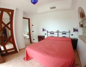 a bedroom with a bed with a red blanket at Tenuta Villa Tara in Ischia