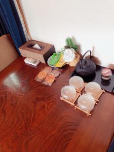 een houten tafel met borden op een houten vloer bij Komorebi in Uji