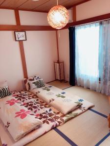 een slaapkamer met 2 bedden en een raam bij Komorebi in Uji