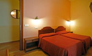 een slaapkamer met een bed met een rood dekbed bij Hotel Ristorante Benigni in Campagnano di Roma